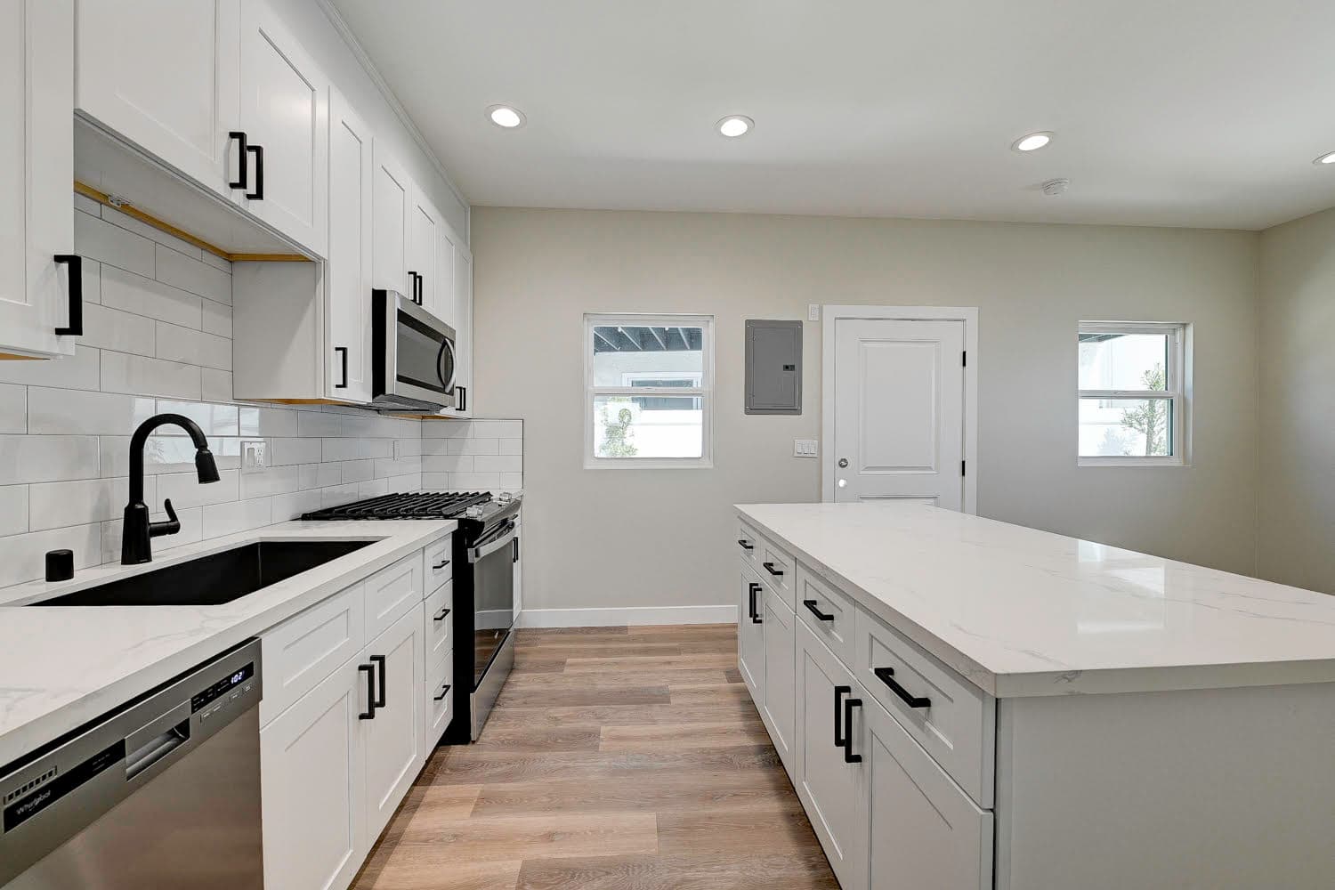 Modern white kitchen remodel with quartz island completed by Navarro's Custom Homes & ADUs in Los Angeles County